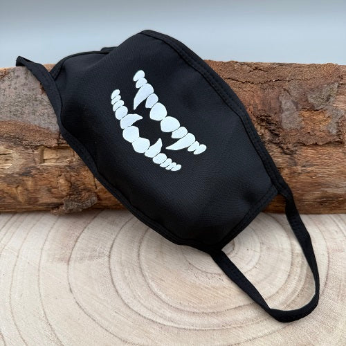 a-black-face-mask-with-a-vampire-smile